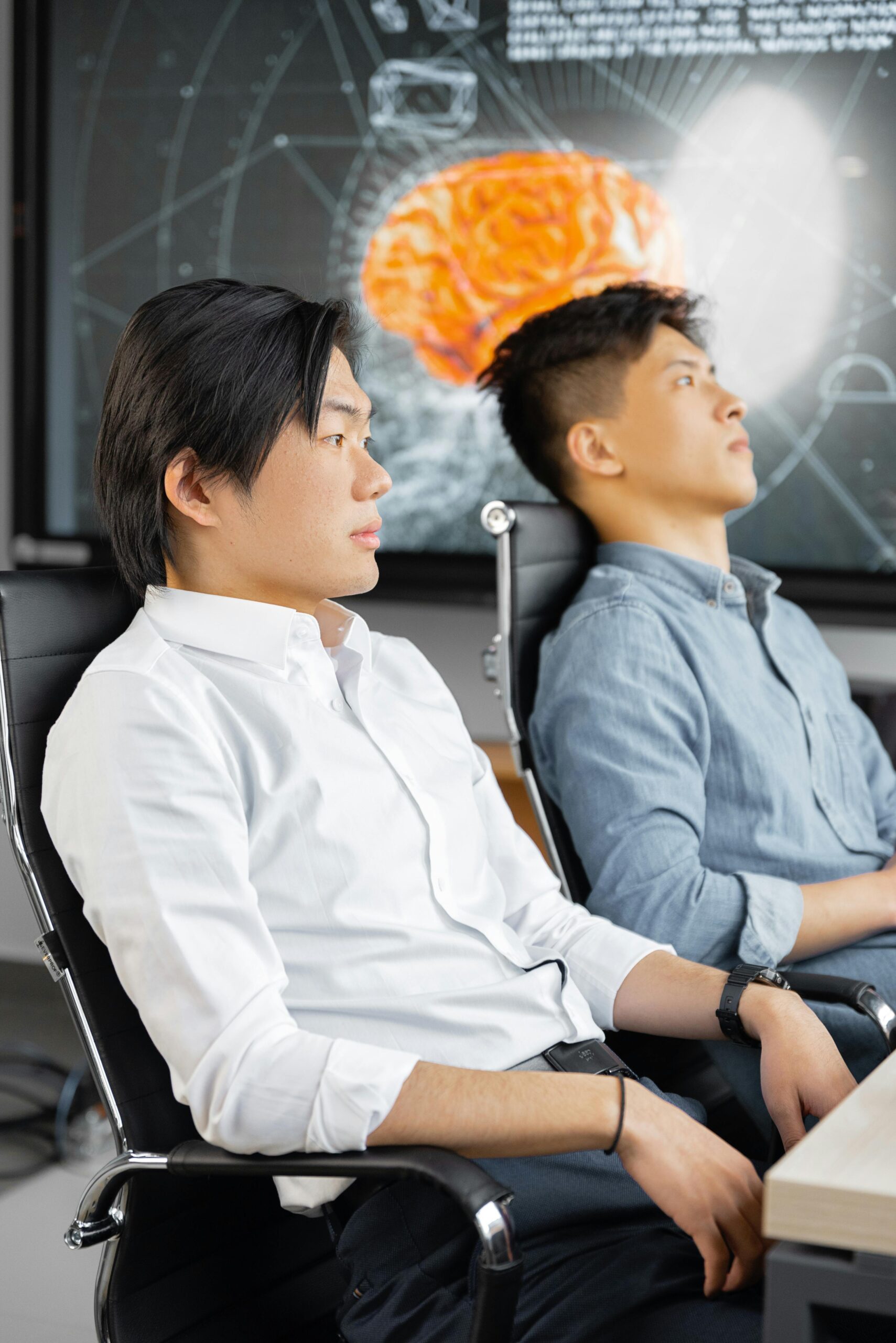 Two businessmen attentively watching a digital presentation in a modern office setting.